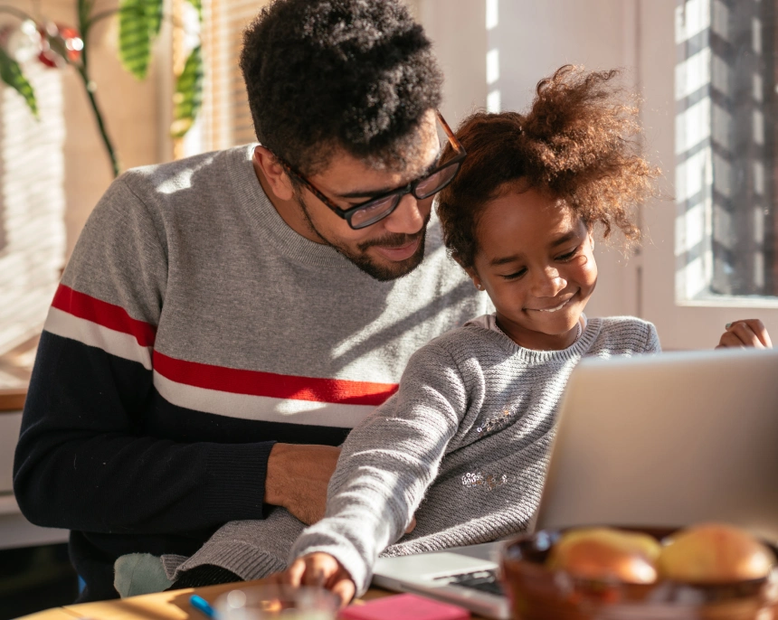An immigrant Latino father and daughter use a computer to check details for their immigration medical examination