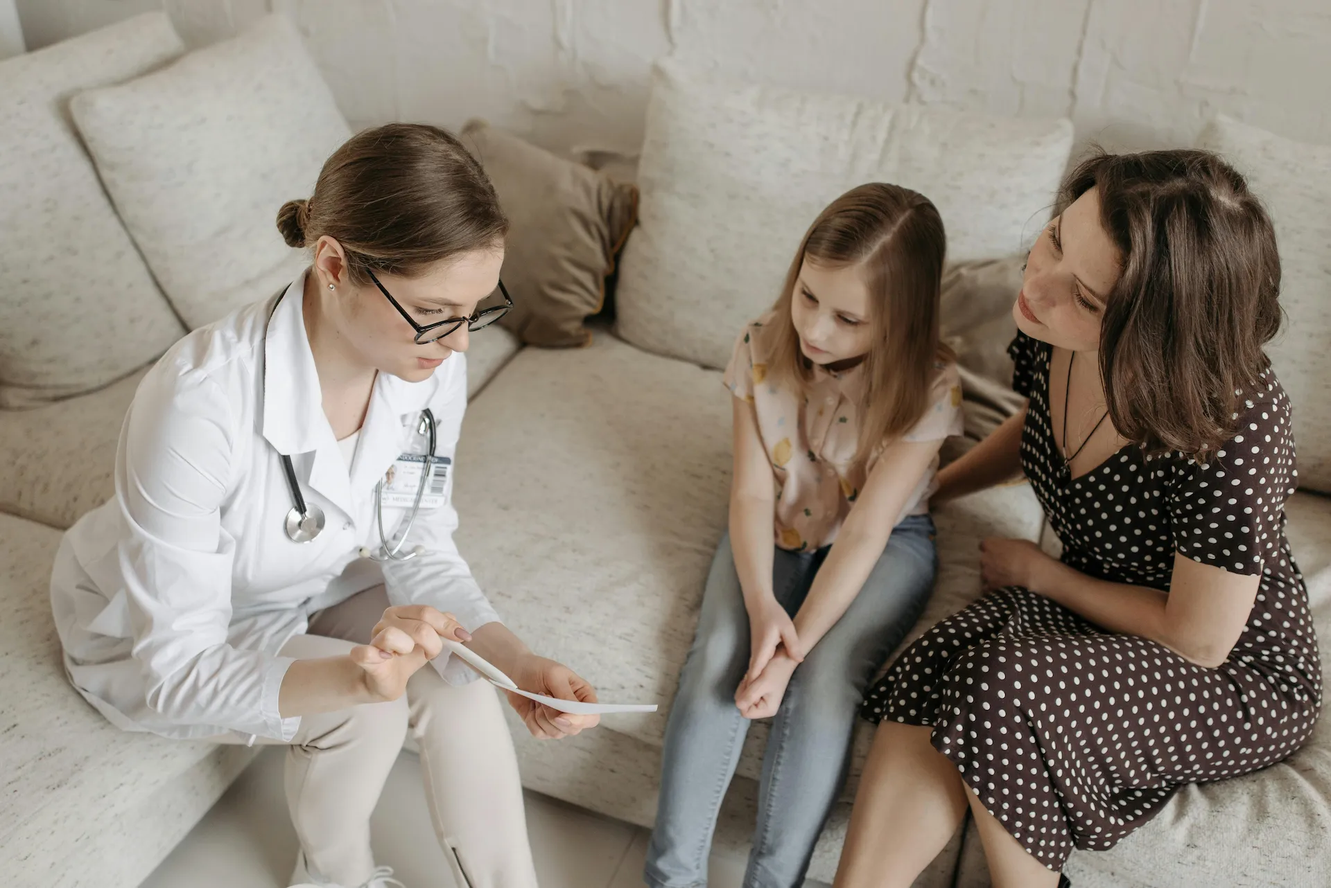 An IMMEDEX physician counsels a mother and child following their immigration medical exam.