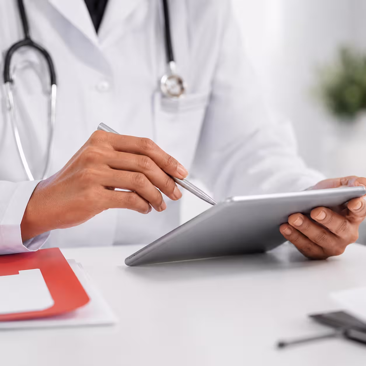physician's hands reviewing a medical chart on a tablet